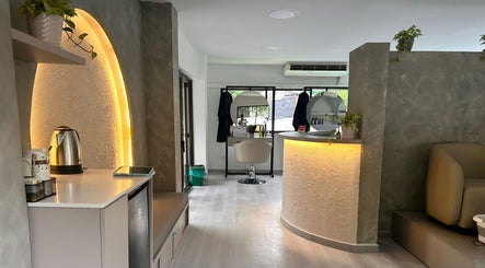 Interior elegante de RADIAN BARBER Y SALÓN en Cali, Valle Del Cauca, CO, mostrando silla de estilista e iluminación cálida.