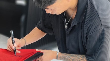 Persona creativa firmando camiseta en SAKURA BARBER STUDIO, Arequipa, Arequipa, PE. Estilo moderno y elegante.