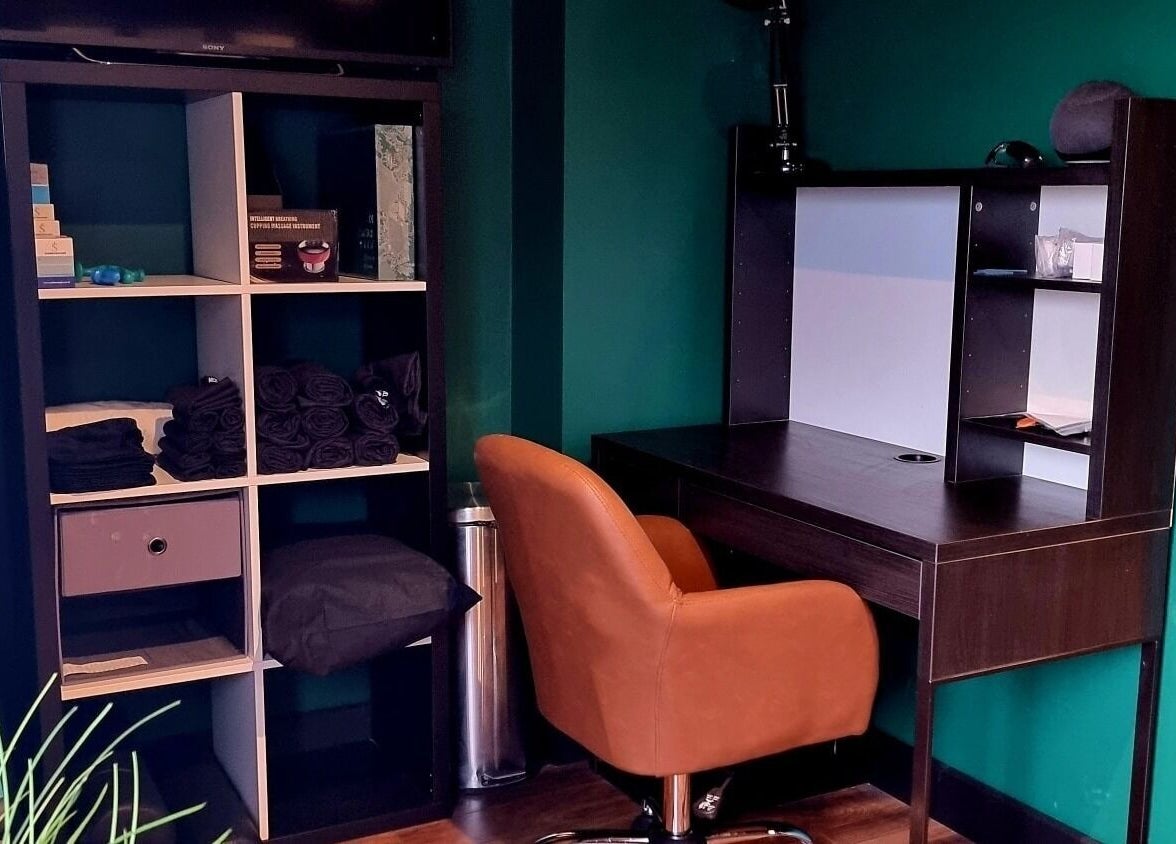 Inviting treatment area at Recovery Room Portadown in Portadown, Northern Ireland, GB with brown chair and desk.