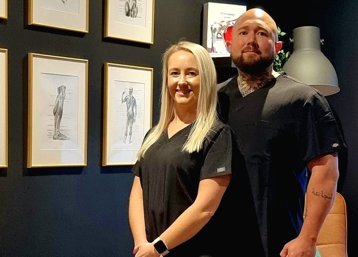 Team members at Recovery Room Portadown, Portadown, Northern Ireland, GB, standing against anatomy artwork.