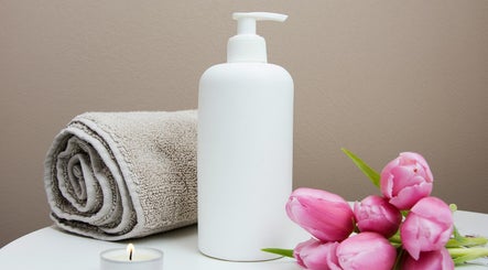 Westland Massage in Denver, Colorado, US offers calming spa essentials with towels, tulips, candle, and lotion.