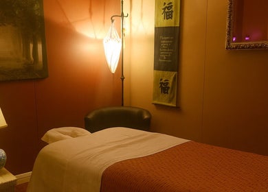 Calming massage room at Sabai Dee Thai Massage, Newport Beach, US, featuring dim lighting and cozy decor.