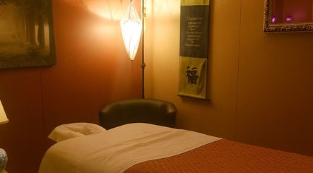 Calming massage room at Sabai Dee Thai Massage, Newport Beach, US, featuring dim lighting and cozy decor.