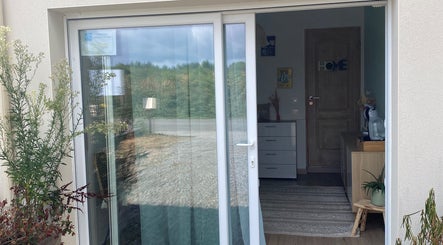 Porte d'entrée élégante de A.Subtil’Art à Peyrilhac, Nouvelle-aquitaine, FR, avec plantes verdoyantes.