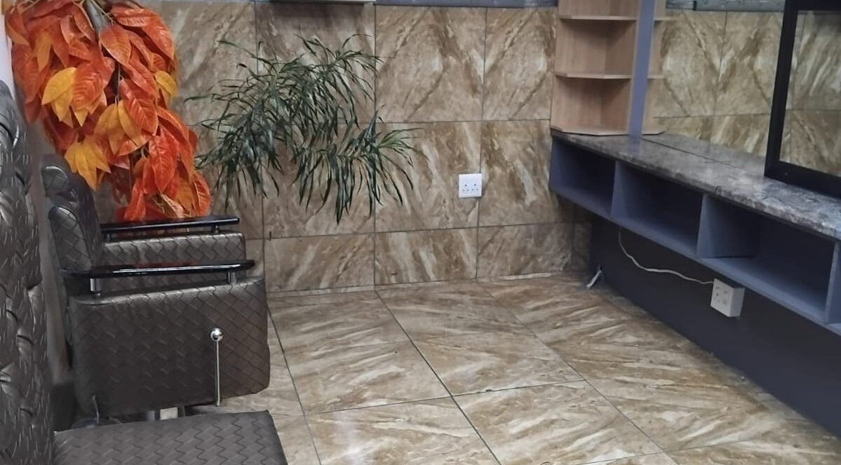 Cozy styling station at FAVOR HAIR STYLIST in Cape Town, Western Cape, ZA with comfortable chairs and decorative plants.