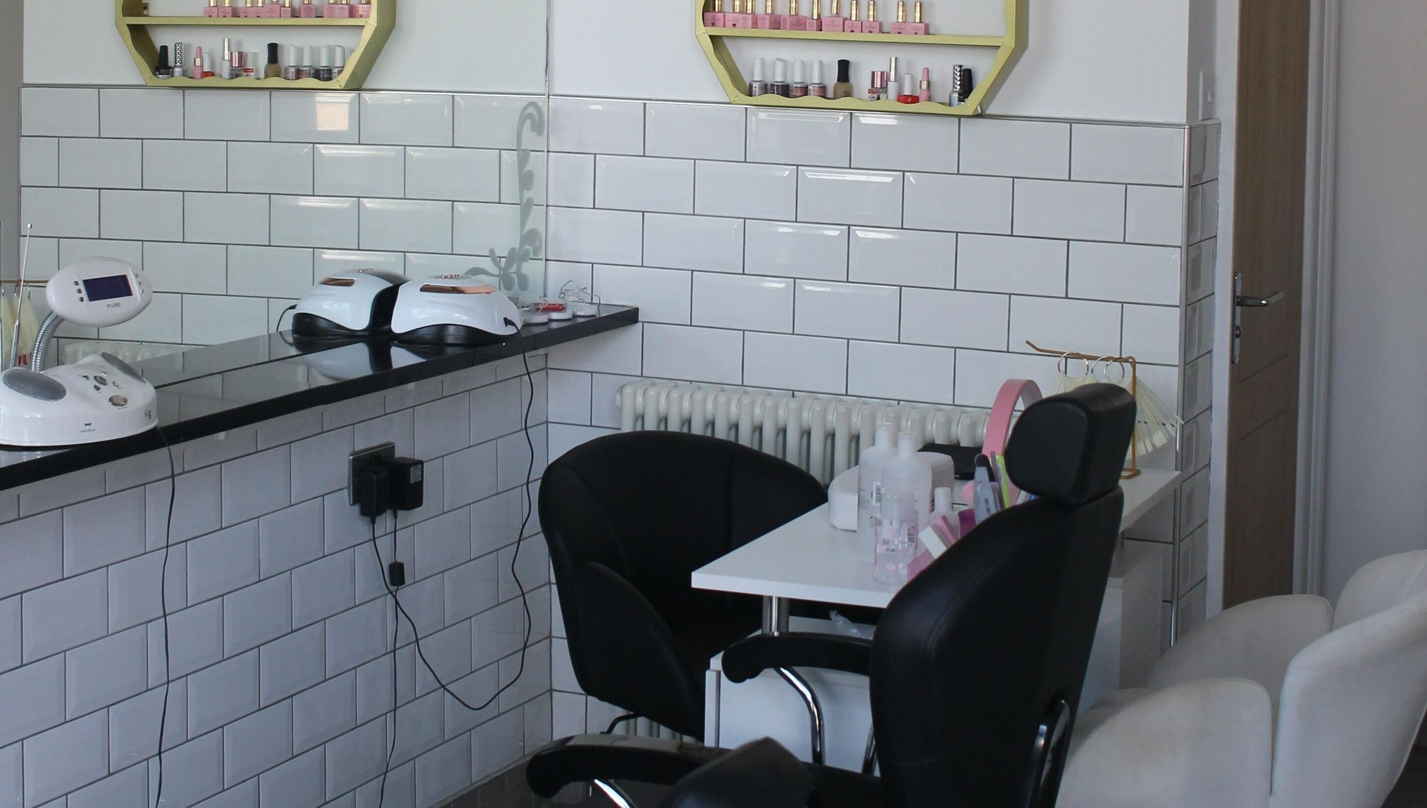 Modern salon corner at Ultimate Beauty, Edinburgh, Scotland, GB with sleek chairs and nail polish display.