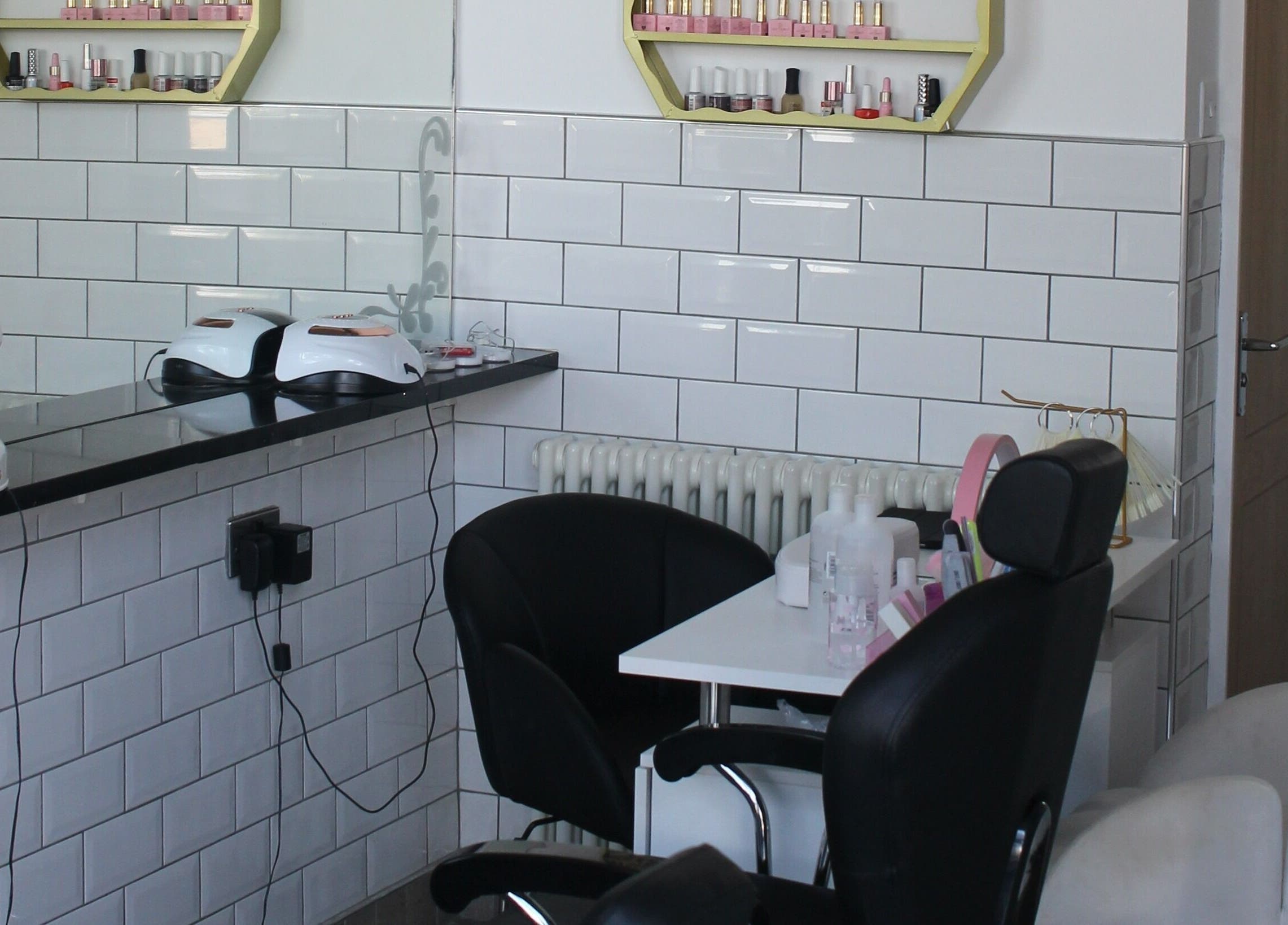 Modern salon corner at Ultimate Beauty, Edinburgh, Scotland, GB with sleek chairs and nail polish display.
