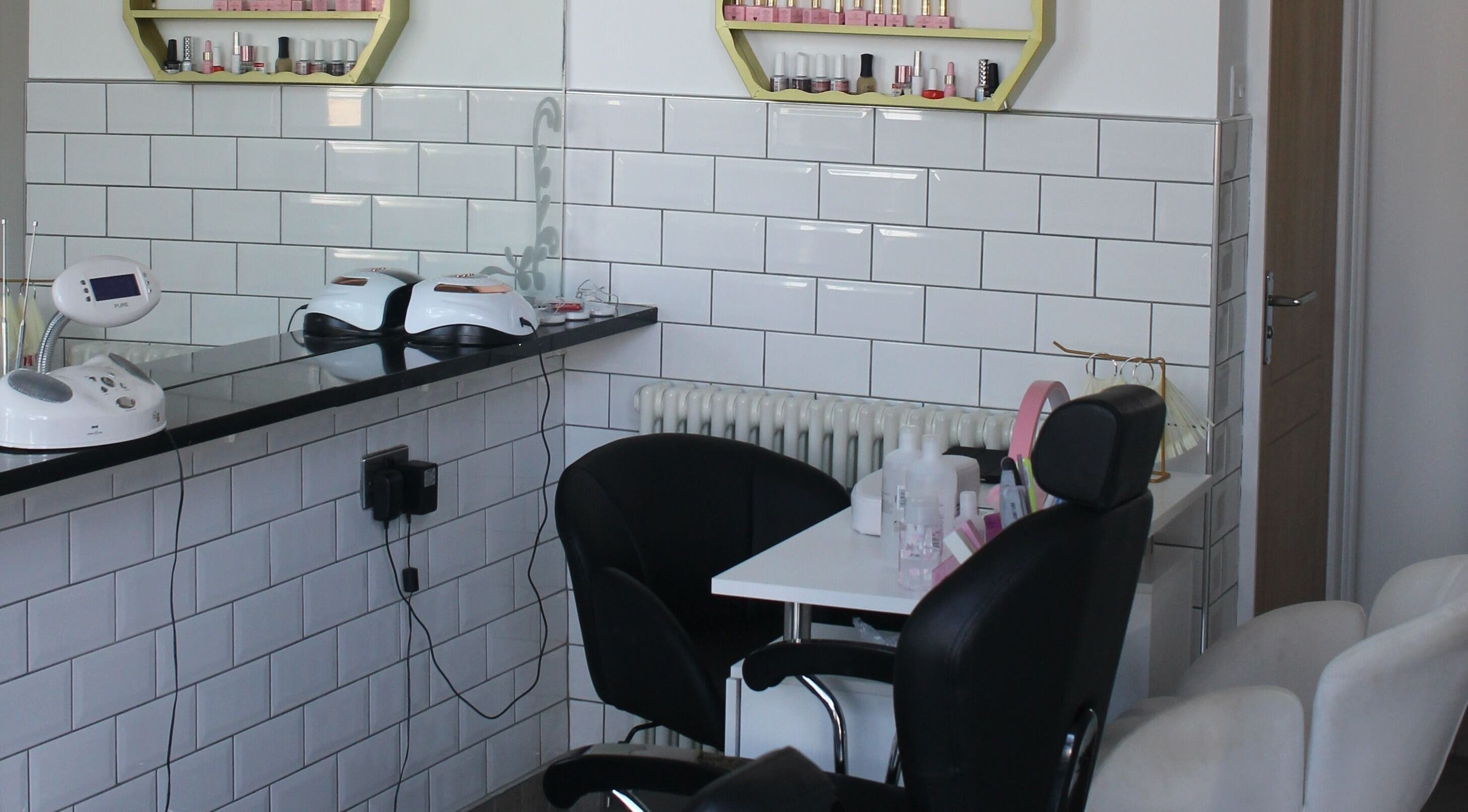 Modern salon corner at Ultimate Beauty, Edinburgh, Scotland, GB with sleek chairs and nail polish display.