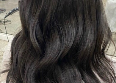 Glossy, styled dark hair at LAYER SALON in Longueuil, Québec, CA, showcasing expert hairstyling skills.