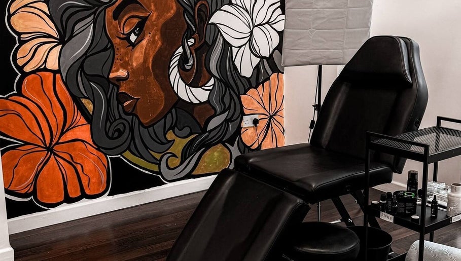 Modern tattoo chair with vibrant mural at VEAN Tattoo, Wolverhampton, England, GB. A creative, inviting space.