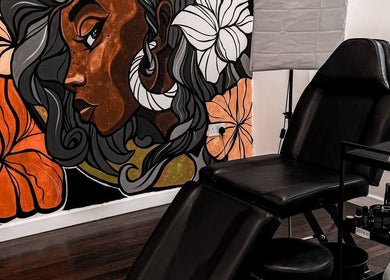 Modern tattoo chair with vibrant mural at VEAN Tattoo, Wolverhampton, England, GB. A creative, inviting space.