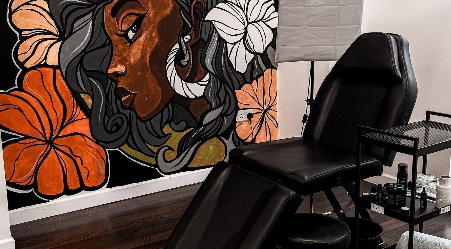 Modern tattoo chair with vibrant mural at VEAN Tattoo, Wolverhampton, England, GB. A creative, inviting space.