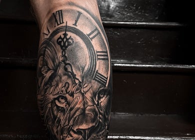Intricate lion and clock tattoo by VEAN Tattoo in Wolverhampton, England, GB, beautifully detailed on a leg.
