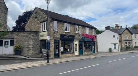 Street view of Faces by MR - Wetherby, highlighting its stone facade in Wetherby, England, GB.