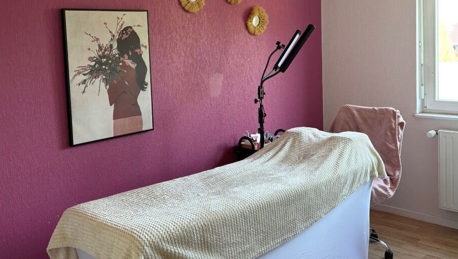 Salle de soin chez Amondomicils à Florange, Grand Est, FR avec décor mural et lit de massage.