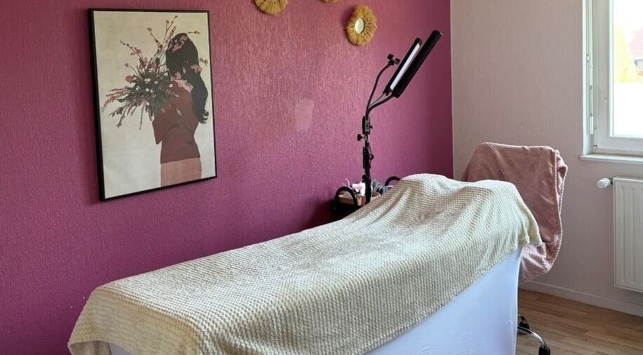 Salle de soin chez Amondomicils à Florange, Grand Est, FR avec décor mural et lit de massage.