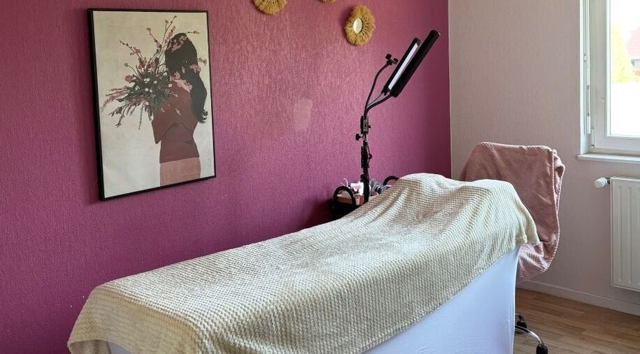 Salle de soin chez Amondomicils à Florange, Grand Est, FR avec décor mural et lit de massage.