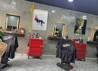 Interior de CENTRAL BARBER SHOP, Toluca De Lerdo, con sillas y decoraciones artísticas.