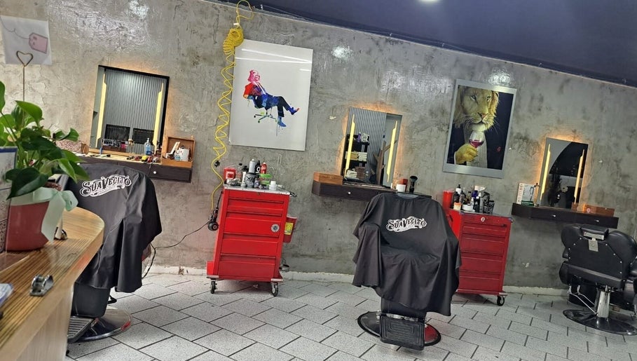 Interior moderno de CENTRAL BARBER SHOP en Toluca De Lerdo, Estado De México, MX con sillones y espejos elegantes.