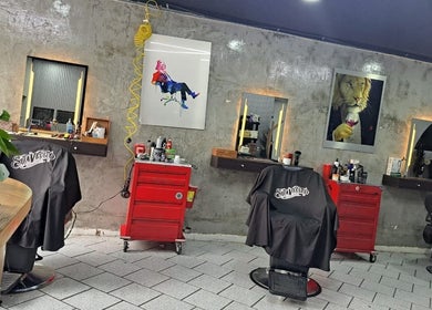 Interior moderno de CENTRAL BARBER SHOP en Toluca De Lerdo, Estado De México, MX con sillones y espejos elegantes.