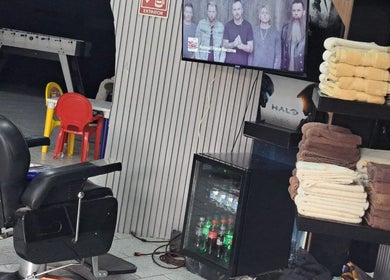 Interior de CENTRAL BARBER SHOP en Toluca De Lerdo, Estado De México, MX, con sillas elegantes y toallas apiladas.