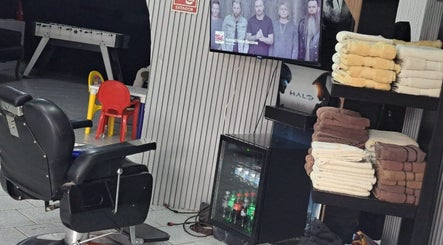 Interior de CENTRAL BARBER SHOP en Toluca De Lerdo, Estado De México, MX, con sillas elegantes y toallas apiladas.