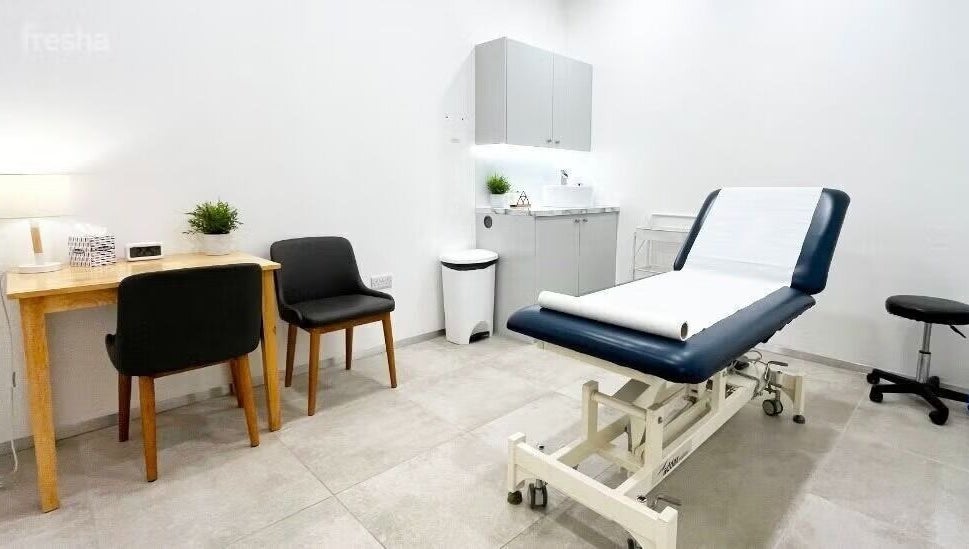 Cozy therapy room at Gosia Massage Therapy in London, England, GB with a massage table and chairs.