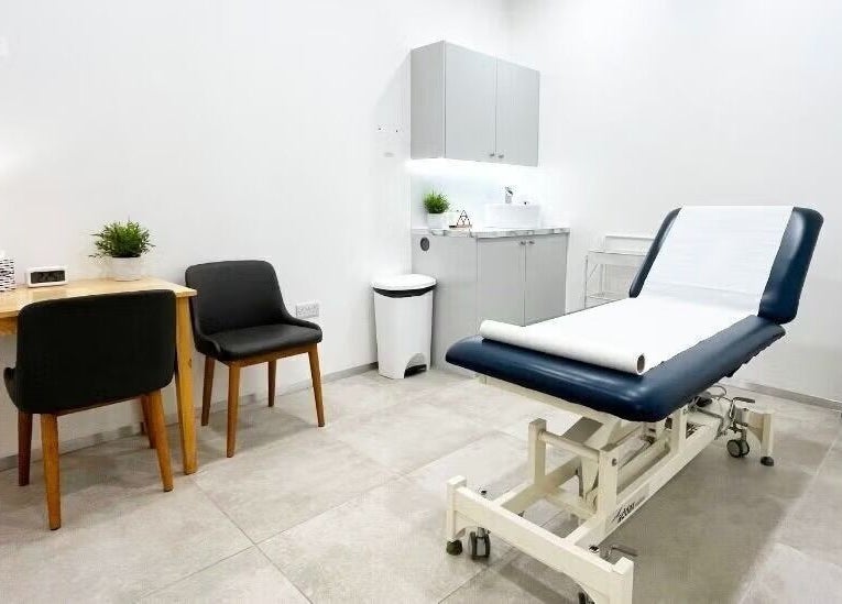 Cozy therapy room at Gosia Massage Therapy in London, England, GB with a massage table and chairs.