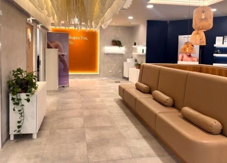 Relaxing seating area at Gosia Massage Therapy, London, England, GB. Modern decor with cream sofas and soft lighting.