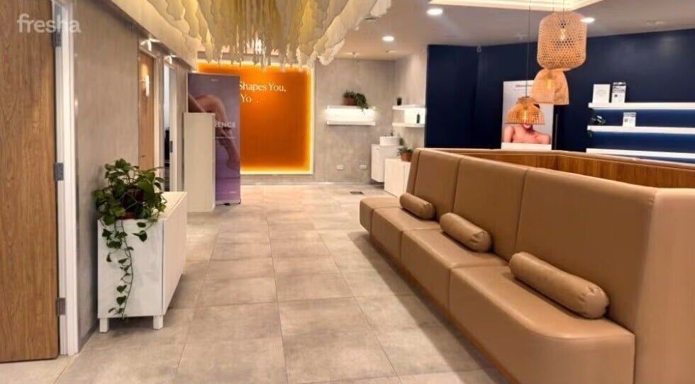 Relaxing seating area at Gosia Massage Therapy, London, England, GB. Modern decor with cream sofas and soft lighting.