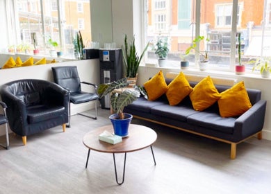 Inviting seating area at Gosia Massage Therapy Clapham in London, England, GB with modern decor and bright cushions.