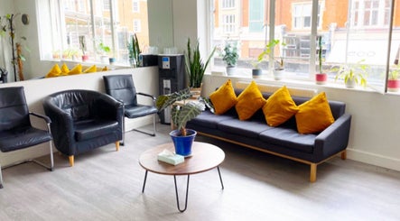 Inviting seating area at Gosia Massage Therapy Clapham in London, England, GB with modern decor and bright cushions.