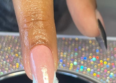 Close-up of a manicured nail at NailswithAmy, Western Cape, Western Cape, ZA with a glittering background.