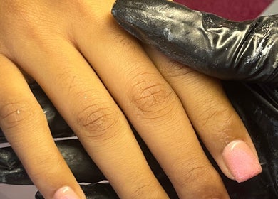 Close-up of freshly painted nails at NailswithAmy, Western Cape, Western Cape, ZA. Hand held by a gloved professional.