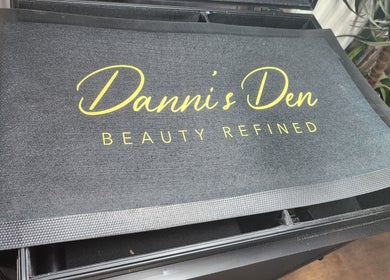 Logo mat at Danni's Den: Beauty Refined in Wellingborough, England, GB.