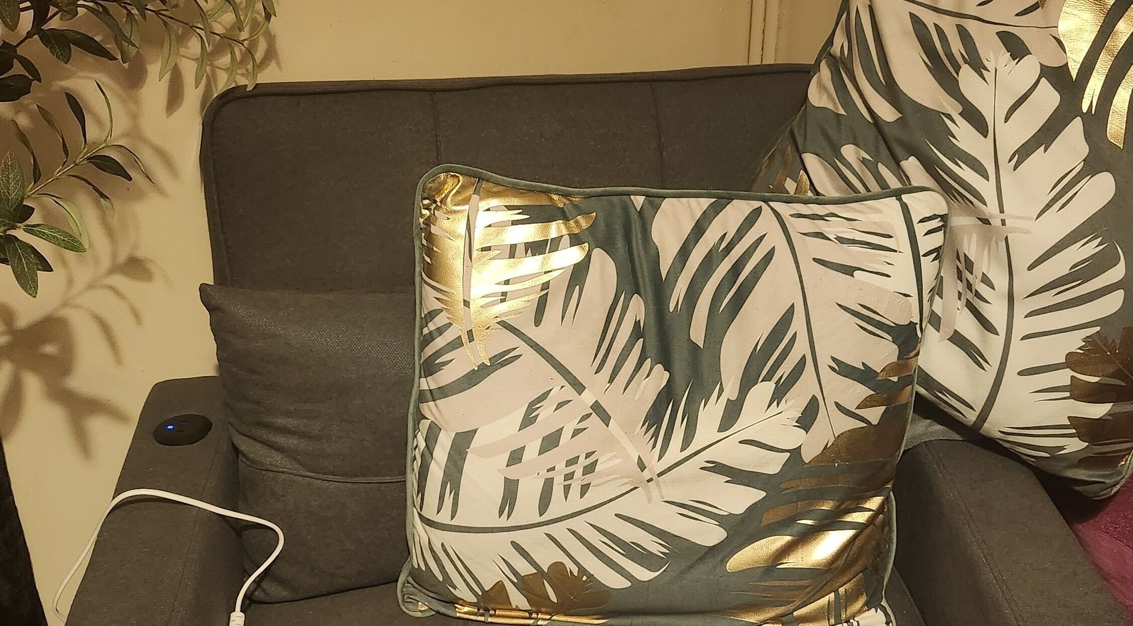 Cozy seating with tropical leaf cushions at Danni's Den: Beauty Refined, Wellingborough, England, GB.