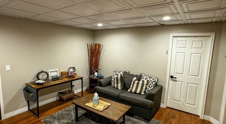 Inviting lounge area at Sol Rise Massage in North Salt Lake, Utah, US, featuring a comfy sofa and elegant decor.