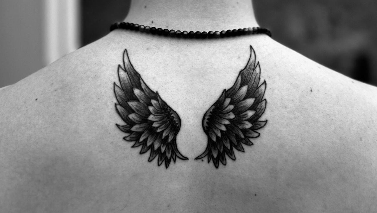 Intricate angel wing tattoo on back at Taisia's Ink Lab, Watford, England, GB, showcasing fine artistry.