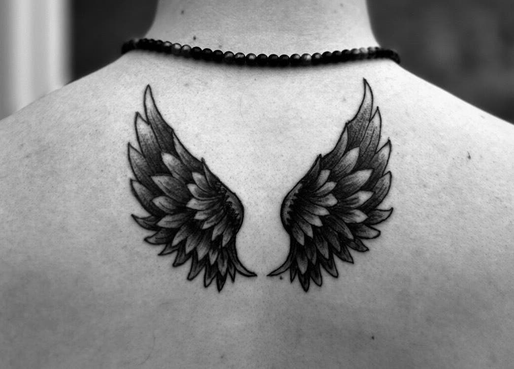 Intricate angel wing tattoo on back at Taisia's Ink Lab, Watford, England, GB, showcasing fine artistry.