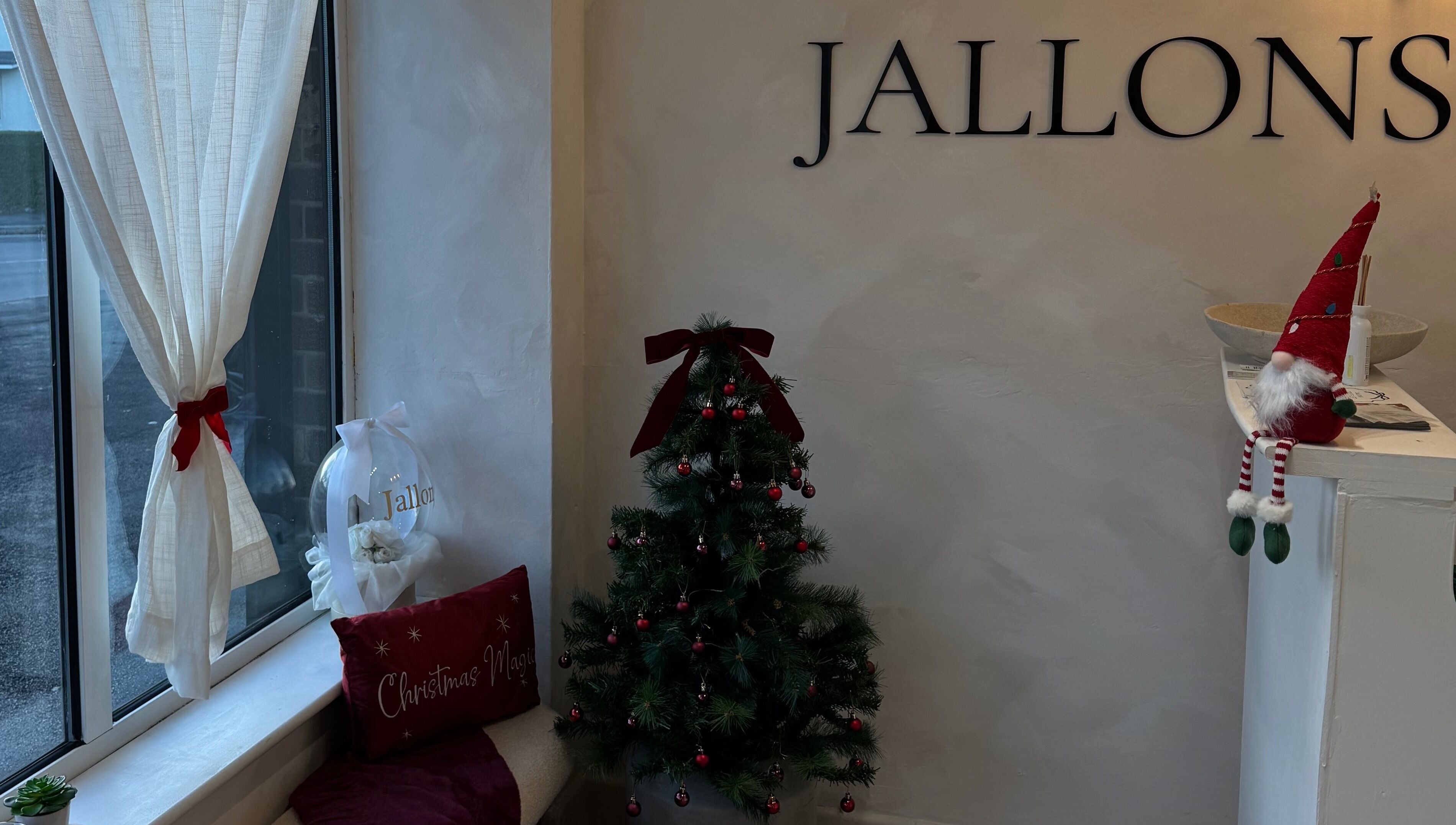 Festive holiday decor at Monetlillyhair, Clifton, England, GB with a small Christmas tree and red accents.
