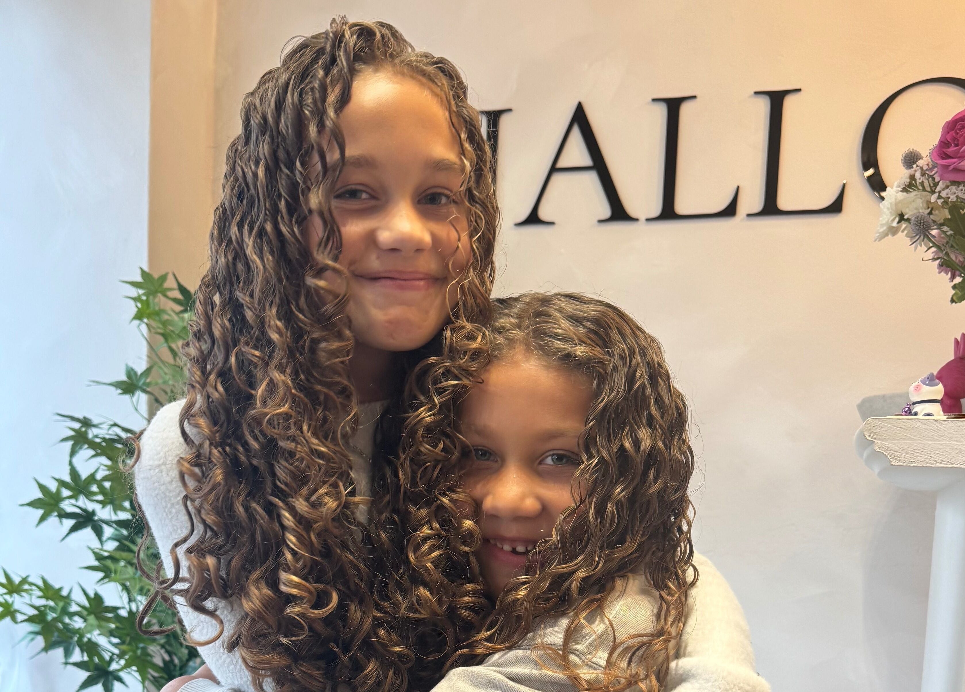 Smiling children with curly hair at Monetlillyhair in Clifton, England, GB, enjoying the cozy salon atmosphere.