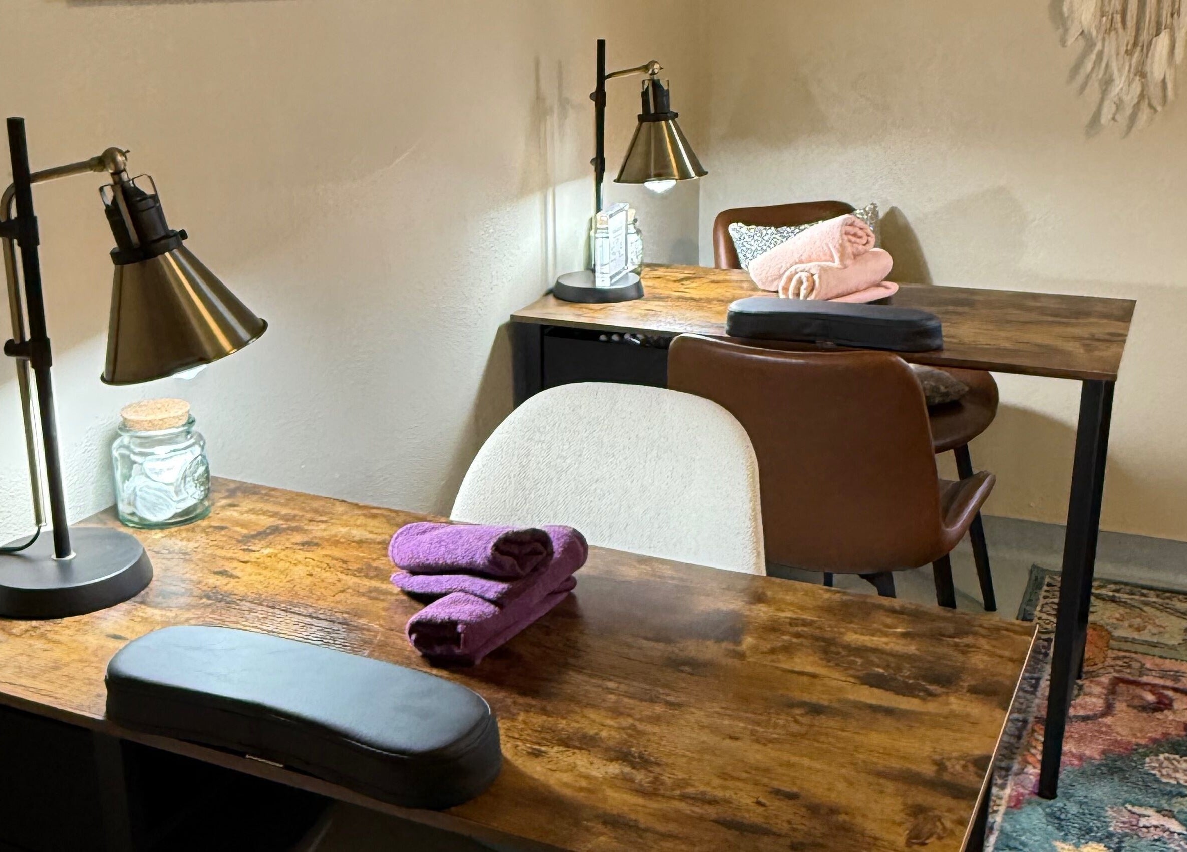 Inviting nail salon setup at Nails By Nikki in Nederland, Colorado, US with plush chairs and wooden tables.