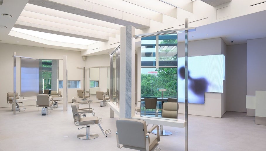 Bright, modern salon interior at HE:ARTS Dosan, Seoul, 서울특별시, KR showcasing sleek design and styling stations.