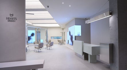 Sleek interior of HE:ARTS Dosan in Seoul, 서울특별시, KR with modern chairs and illuminated walls.