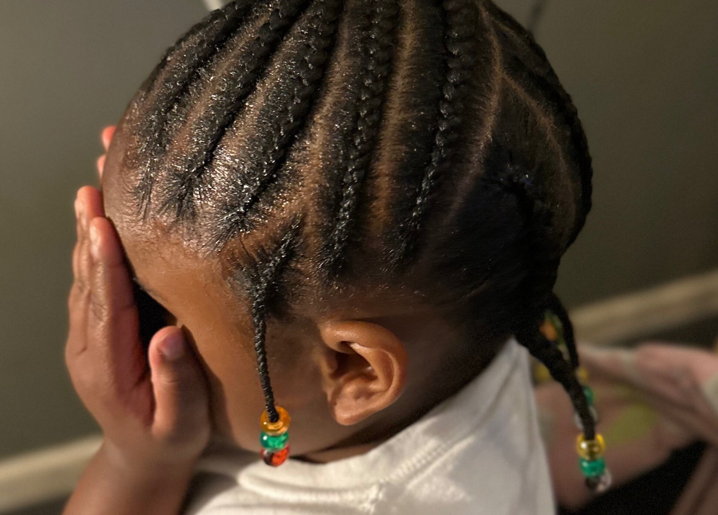 Intricate cornrow braids on a child's head with beads at Natural Braids By Val, Indianapolis, Indiana, US.