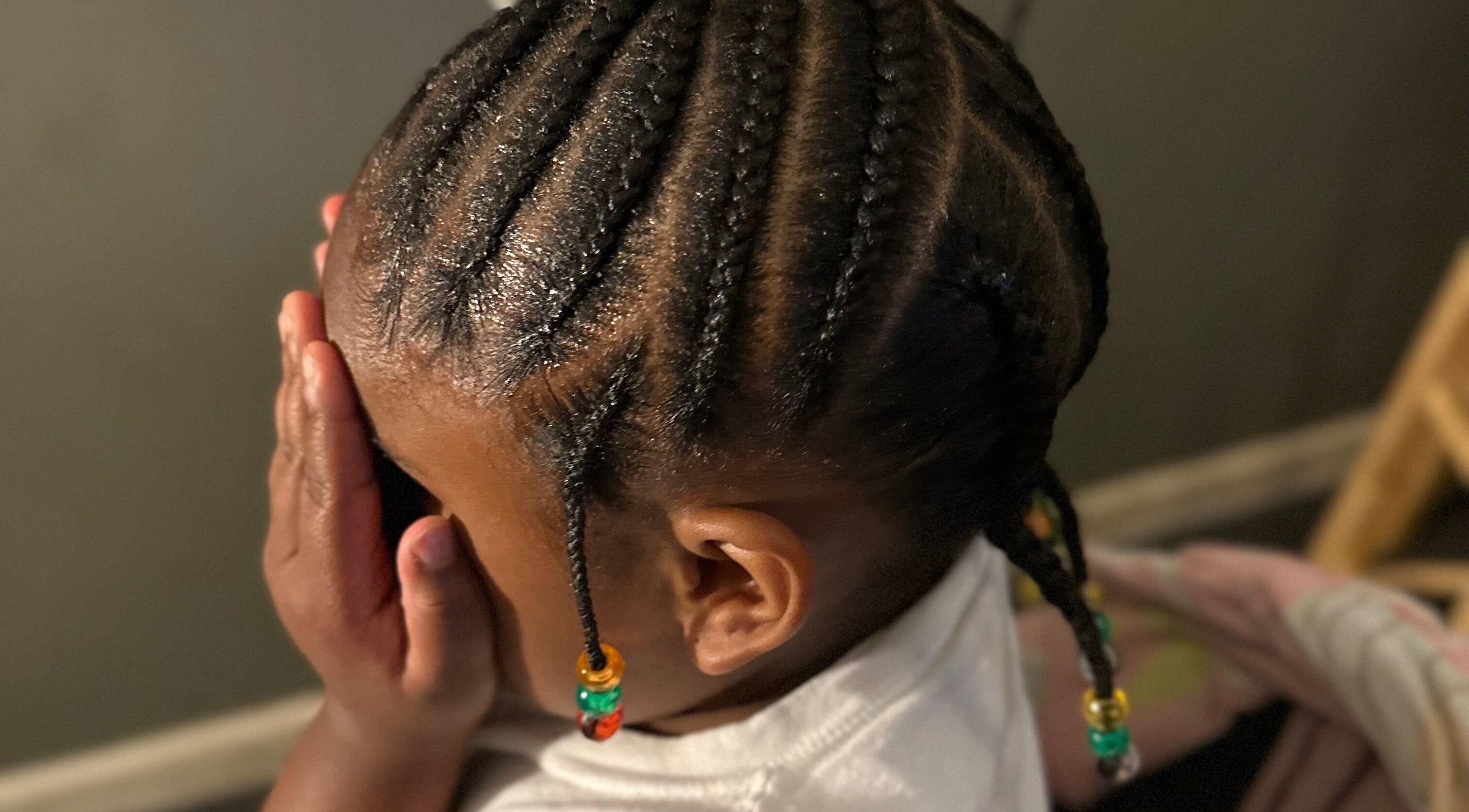 Intricate cornrow braids on a child's head with beads at Natural Braids By Val, Indianapolis, Indiana, US.
