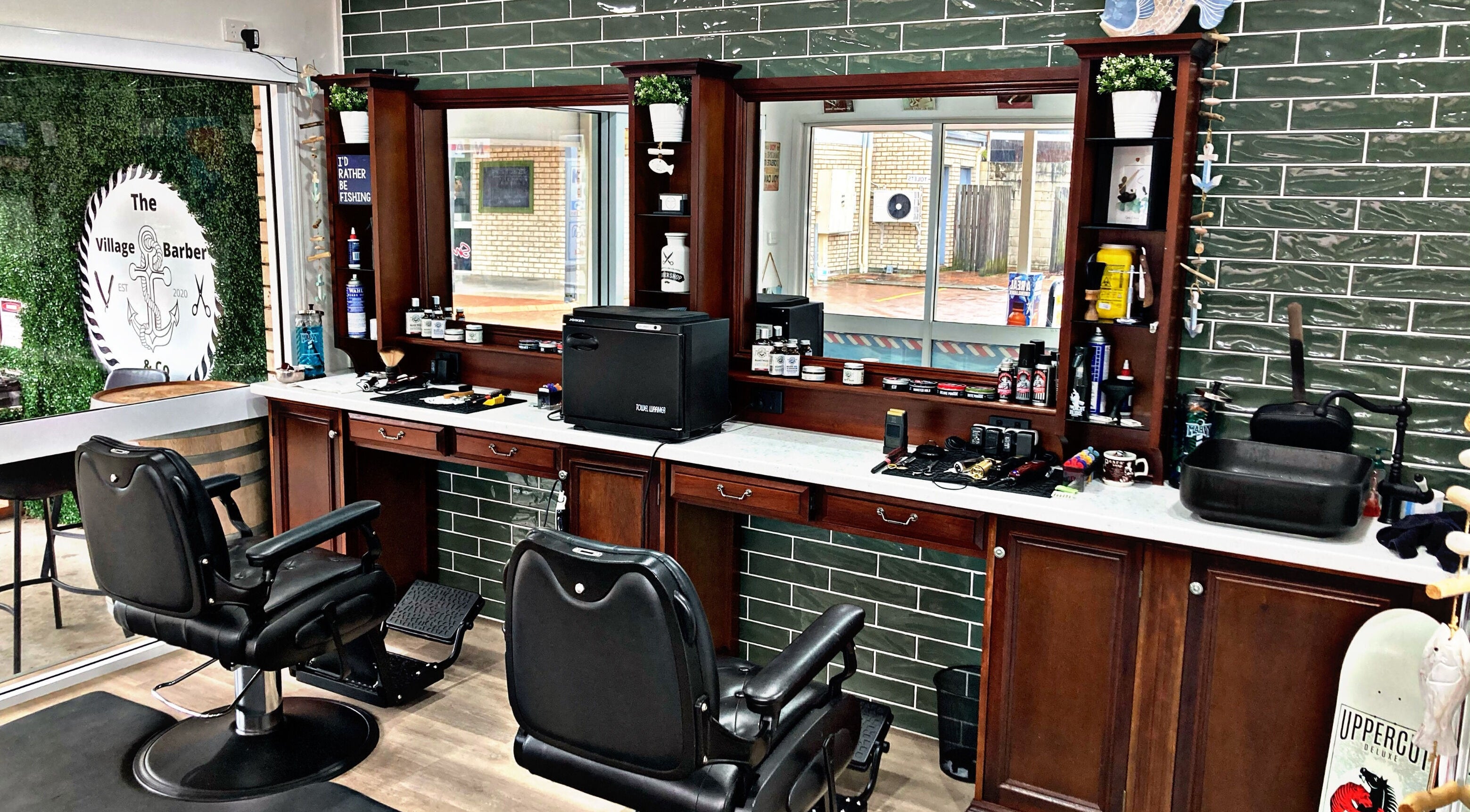 Interior of The Village Barber & Co, Scarness, Queensland, AU, showcasing elegant chairs and grooming products.