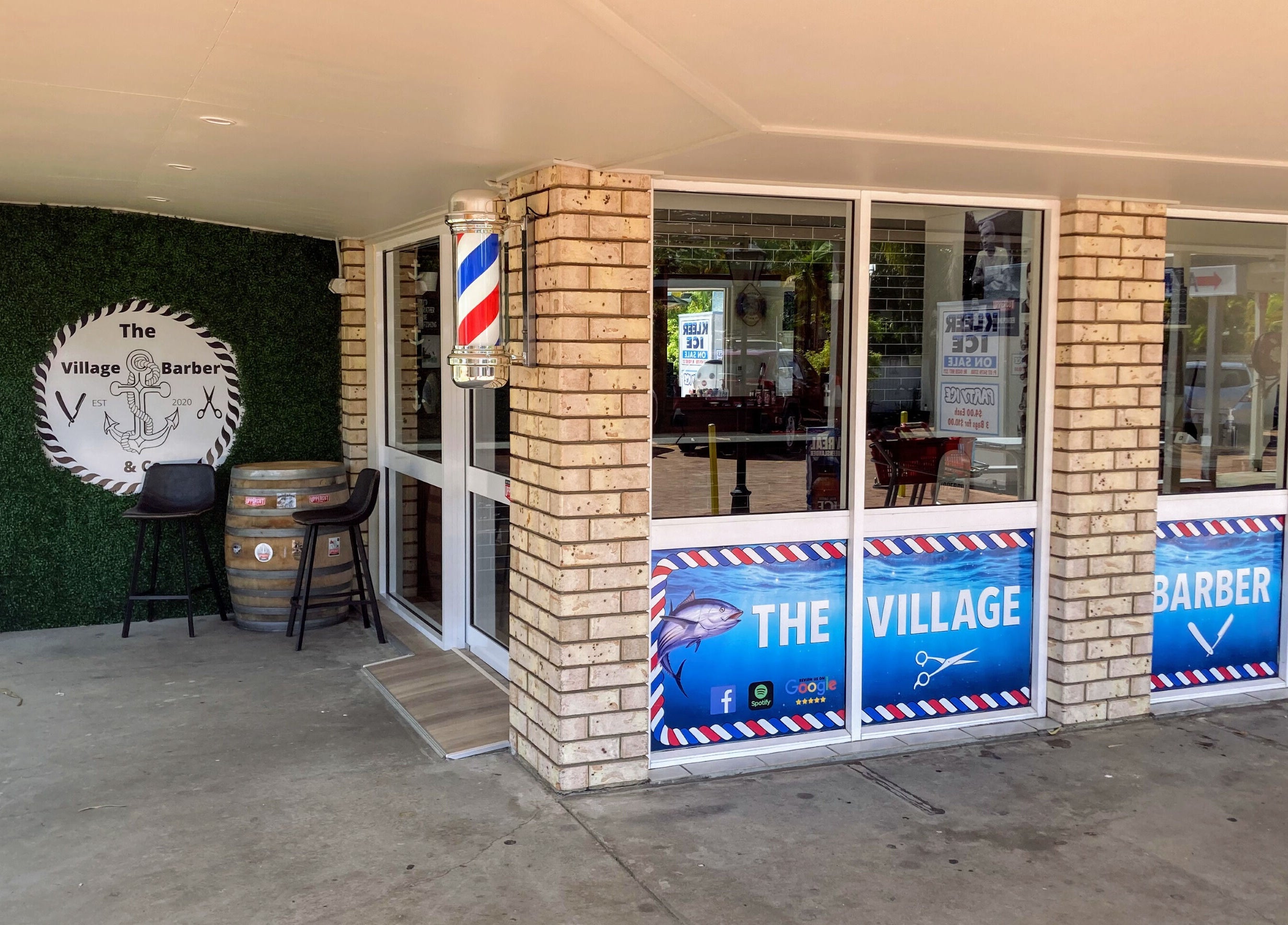 Entrance of The Village Barber & Co in Scarness, Queensland, AU, featuring brick facade and classic barber pole.