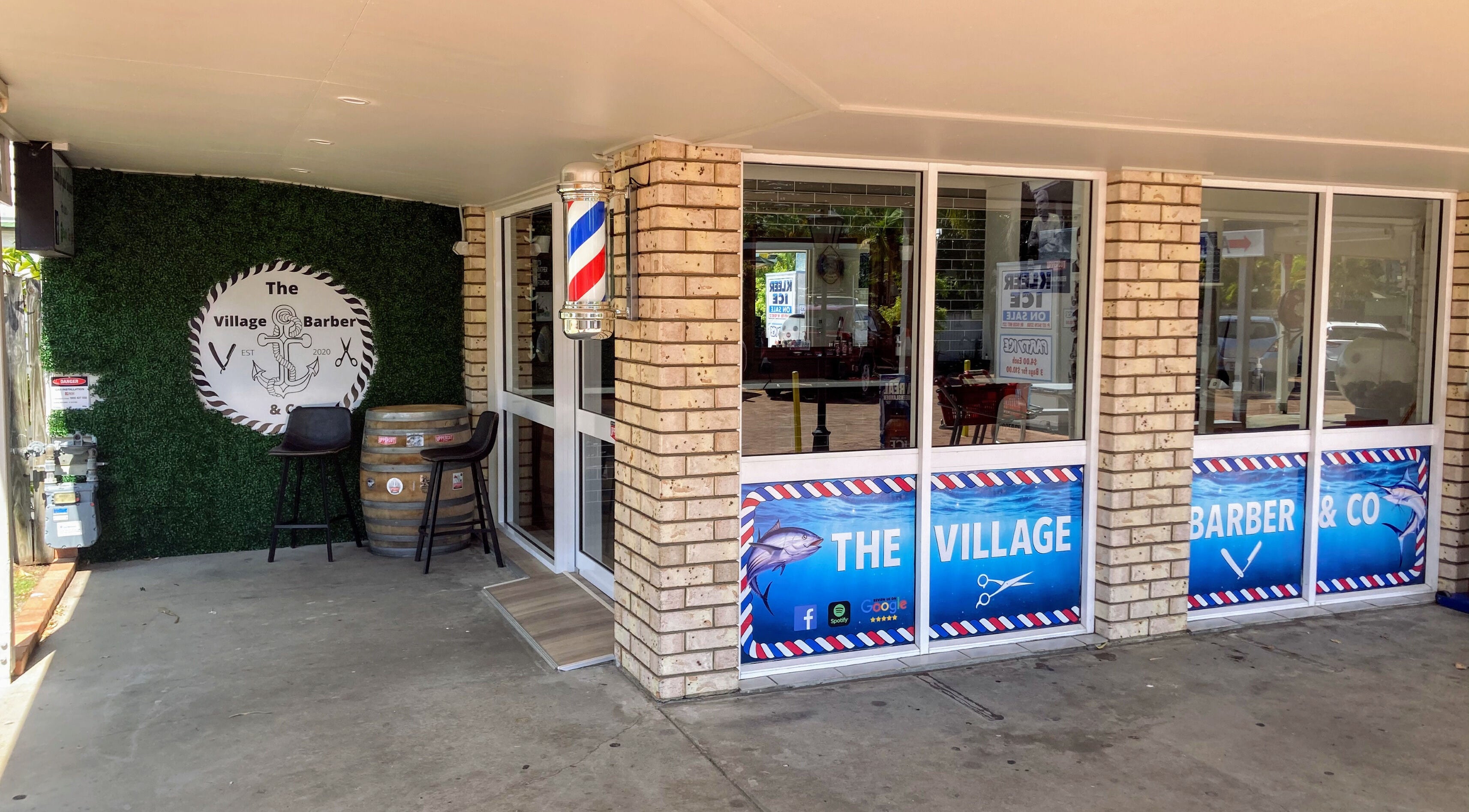 Entrance of The Village Barber & Co in Scarness, Queensland, AU, featuring brick facade and classic barber pole.