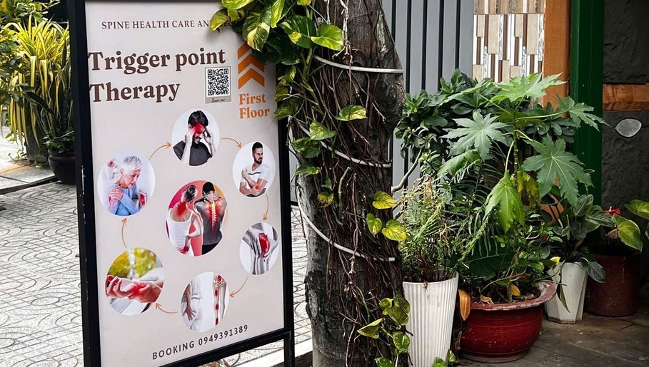 Bảng quảng cáo trị liệu đau điểm tại YEN THERAPY, Hồ Chí Minh, VN với cây cối xanh tươi xung quanh.